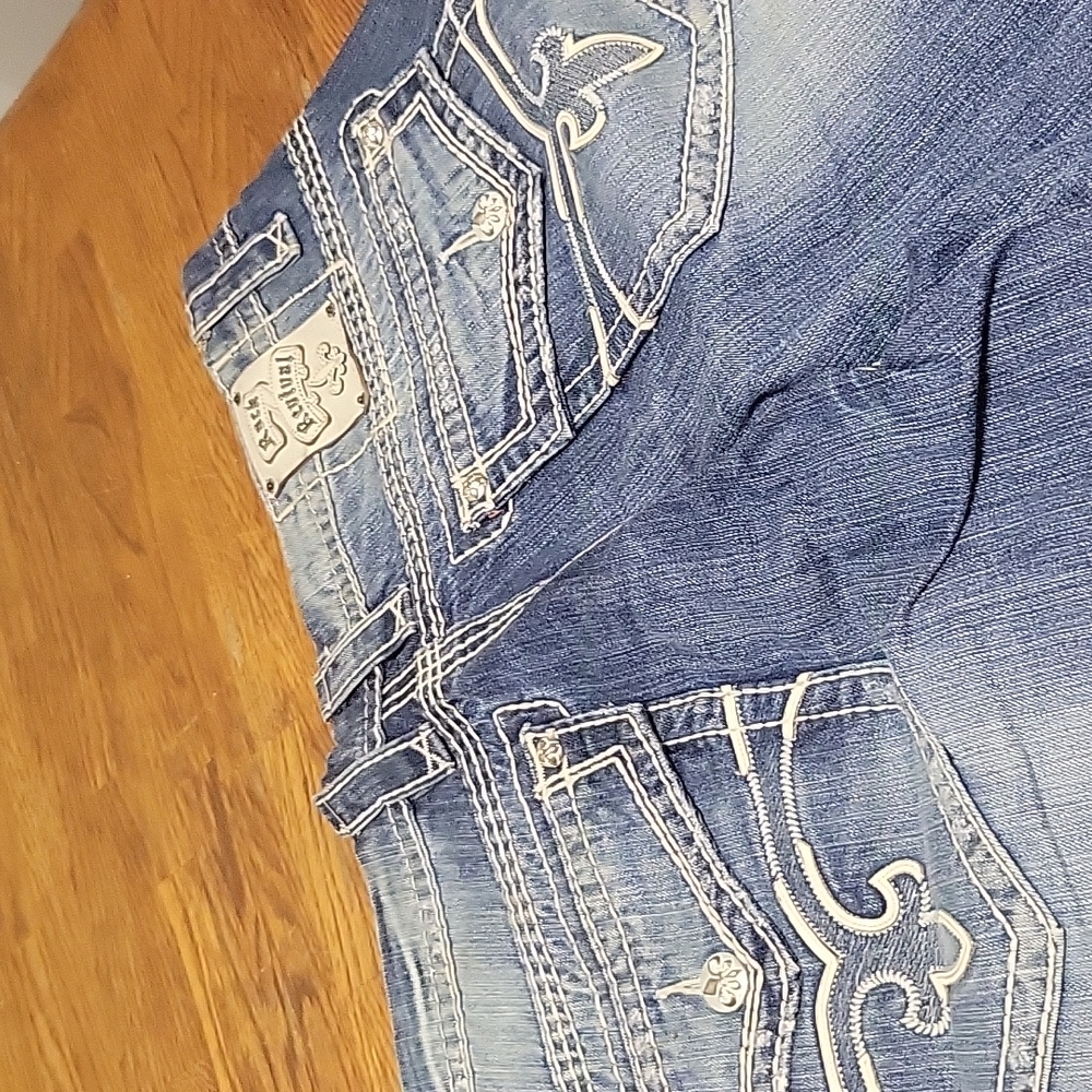 A nice clean pair of Rock Revival blue Jeans with white stitching and flare leg